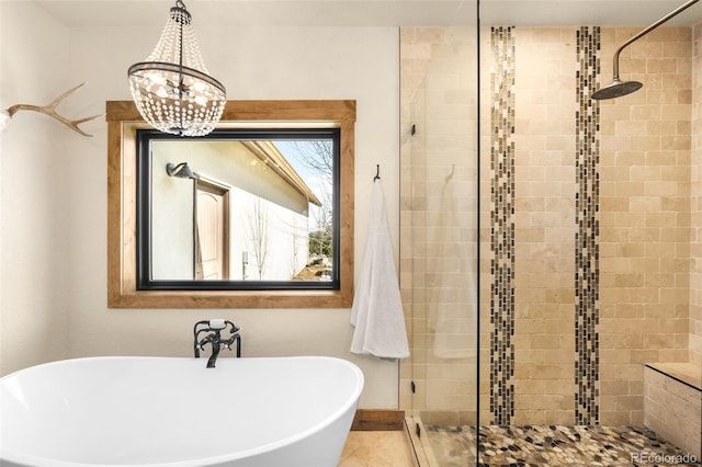 full bathroom with a freestanding tub, a notable chandelier, baseboards, and a stall shower