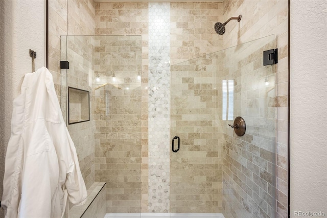 bathroom featuring a stall shower and a textured wall