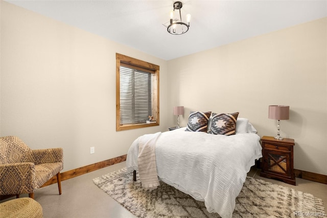 carpeted bedroom featuring a notable chandelier and baseboards