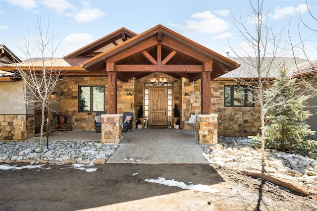 property entrance with a porch and stone siding