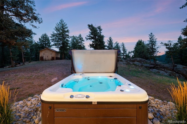 yard at dusk featuring a hot tub