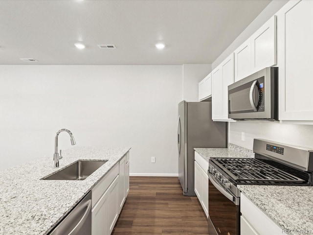 1618 Riverplace Dr Unit 2, Windsor, CO 80550 - kitchen featuring stainless steel appliances, a sink, dark wood-style flooring, light stone counters, and white cabinetry