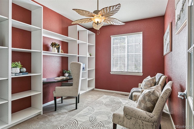 living area with a textured ceiling, ceiling fan, and carpet floors