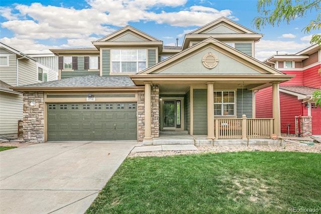 view of front of house featuring a porch, a garage, and a front lawn