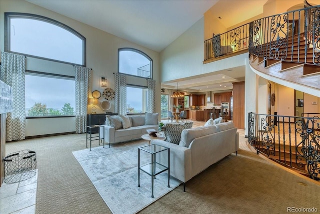 16713 W Archer Ave, Golden, CO 80401 - living area featuring high vaulted ceiling, plenty of natural light, light colored carpet, stairway, and a chandelier