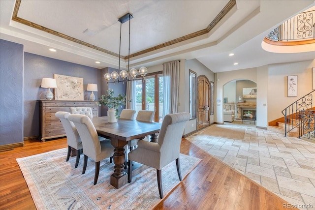 16713 W Archer Ave, Golden, CO 80401 - dining space featuring a tray ceiling, arched walkways, ornamental molding, stairway, and baseboards