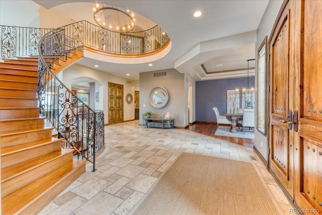 16713 W Archer Ave, Golden, CO 80401 - foyer entrance with a chandelier, arched walkways, stone tile flooring, recessed lighting, and a raised ceiling