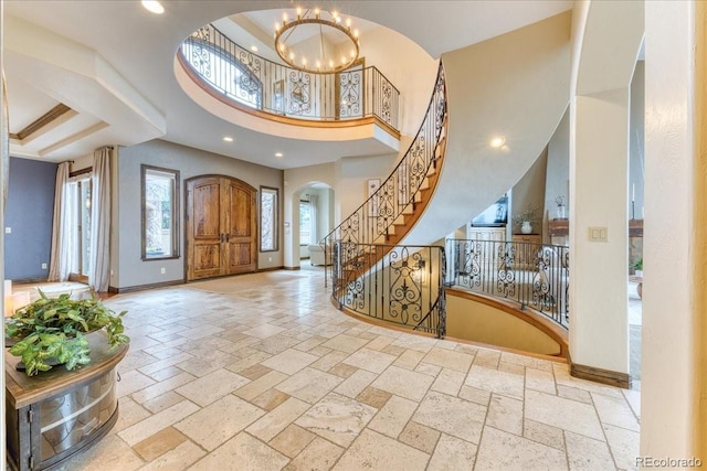 16713 W Archer Ave, Golden, CO 80401 - entrance foyer featuring stone tile floors, a chandelier, baseboards, arched walkways, and stairs
