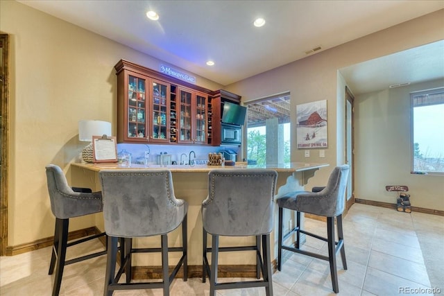 16713 W Archer Ave, Golden, CO 80401 - indoor wet bar with stainless steel microwave, recessed lighting, baseboards, and light tile patterned floors