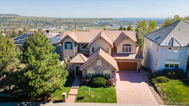 16713 W Archer Ave, Golden, CO 80401 - view of front of house with stone siding, concrete driveway, an attached garage, a tile roof, and stucco siding