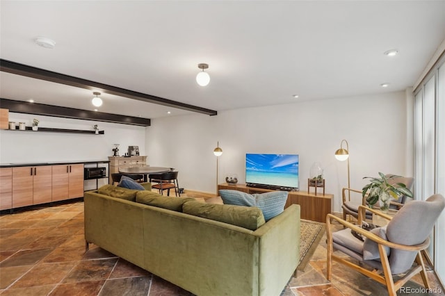 living room featuring beam ceiling and dark tile flooring