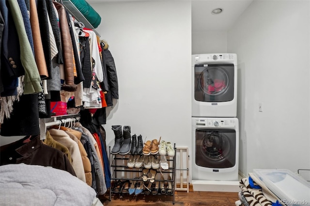 spacious closet featuring stacked washer and clothes dryer and hardwood / wood-style flooring