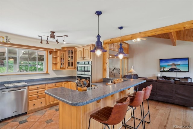 kitchen with stainless steel appliances, beam ceiling, decorative light fixtures, light tile floors, and a breakfast bar