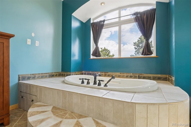 bathroom with tile flooring and tiled tub