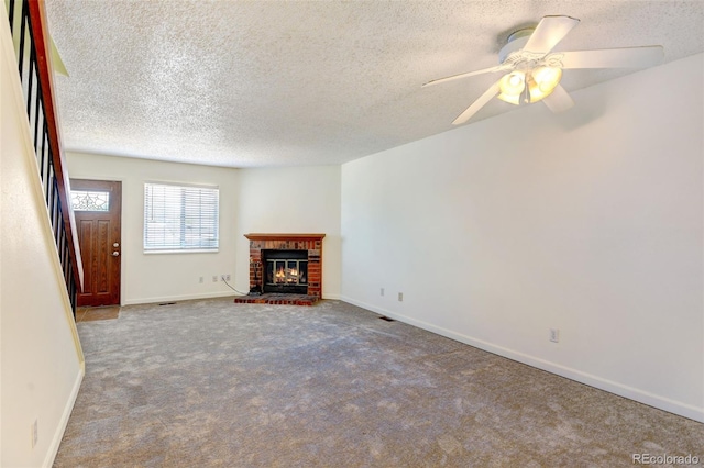 unfurnished living room with ceiling fan, carpet floors, a textured ceiling, and a brick fireplace