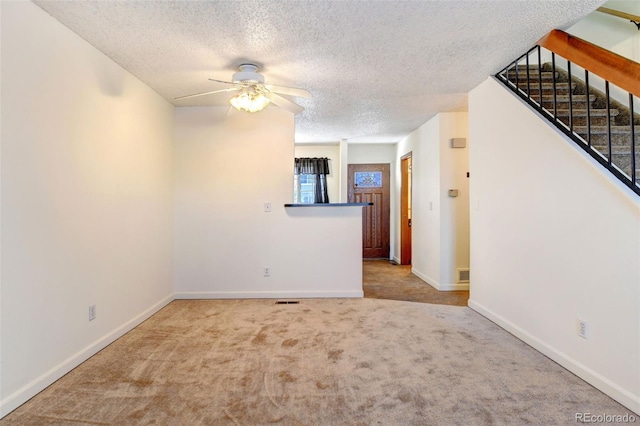 unfurnished room with light carpet, a textured ceiling, and ceiling fan