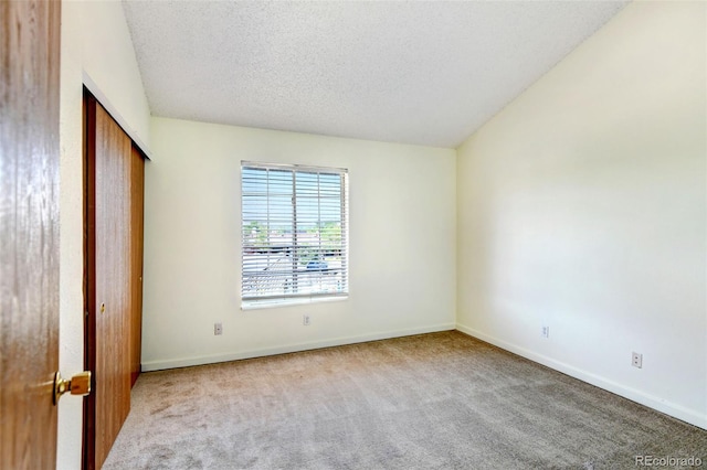 unfurnished bedroom with a textured ceiling and light carpet