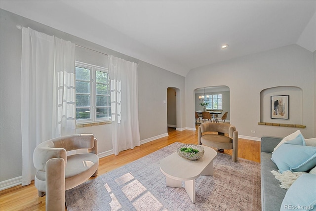 2065 Leyden St, Denver, CO 80207 - living area with arched walkways, vaulted ceiling, wood finished floors, a chandelier, and baseboards