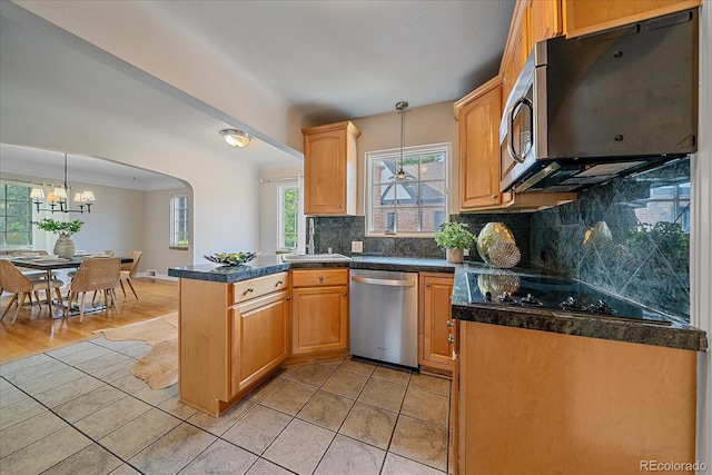 2065 Leyden St, Denver, CO 80207 - kitchen with stainless steel appliances, a peninsula, tasteful backsplash, a chandelier, and decorative light fixtures
