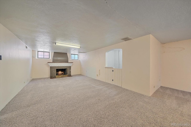 2065 Leyden St, Denver, CO 80207 - basement featuring a textured ceiling, carpet flooring, and a brick fireplace
