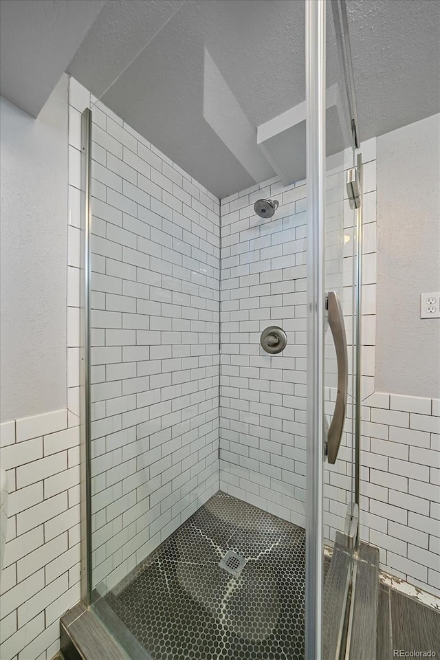 2065 Leyden St, Denver, CO 80207 - full bath featuring a shower stall, tile walls, a textured ceiling, a wainscoted wall, and a textured wall