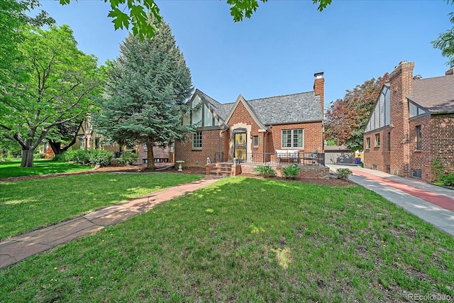2065 Leyden St, Denver, CO 80207 - view of front of property featuring brick siding, a front lawn, and a chimney