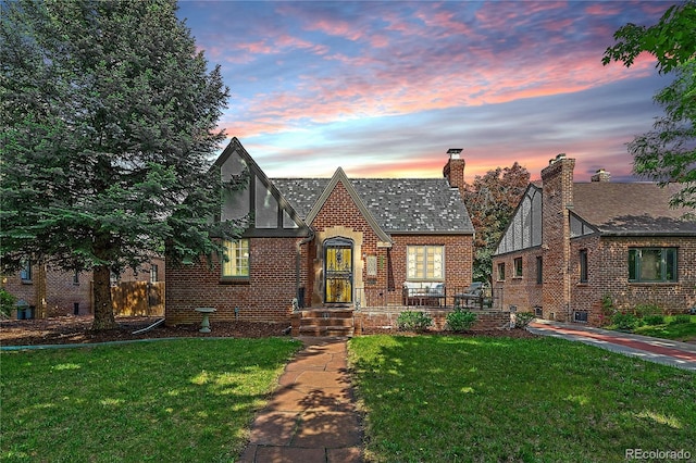 2065 Leyden St, Denver, CO 80207 - english style home with a yard, a chimney, and brick siding