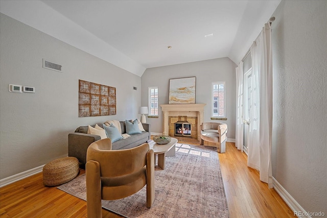 2065 Leyden St, Denver, CO 80207 - living room featuring light wood-style floors, vaulted ceiling, a fireplace, and baseboards