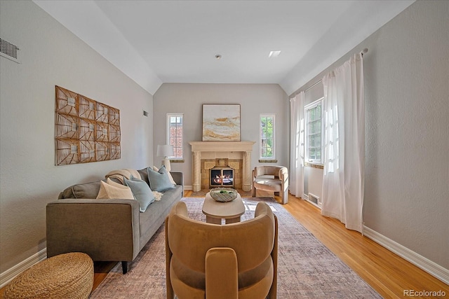 2065 Leyden St, Denver, CO 80207 - living area featuring light wood-style floors, vaulted ceiling, baseboards, and a stone fireplace