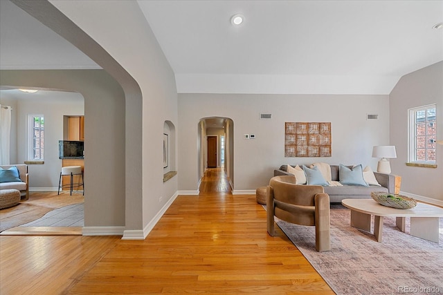 2065 Leyden St, Denver, CO 80207 - living area featuring arched walkways, light wood-style floors, and baseboards