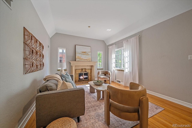 2065 Leyden St, Denver, CO 80207 - living room featuring healthy amount of natural light, vaulted ceiling, light wood-style floors, a fireplace, and baseboards