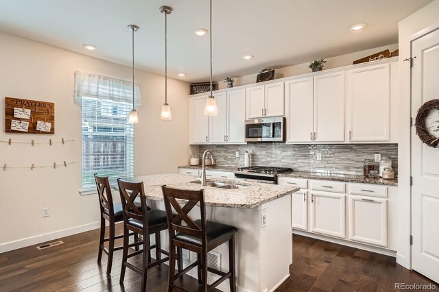 16043 Fillmore St, Thornton, CO 80602 - kitchen with stainless steel microwave, range, decorative backsplash, dark wood-type flooring, and a breakfast bar area