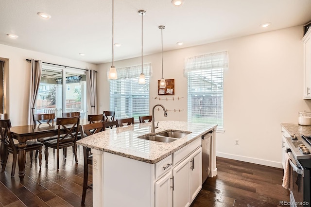 16043 Fillmore St, Thornton, CO 80602 - kitchen featuring dark wood-type flooring, a kitchen breakfast bar, appliances with stainless steel finishes, hanging light fixtures, and white cabinets