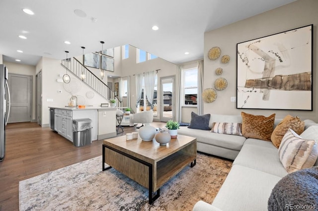 living room with wood-type flooring, an inviting chandelier, and sink