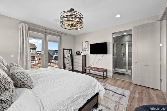 bedroom with light wood-type flooring, access to outside, an inviting chandelier, and connected bathroom