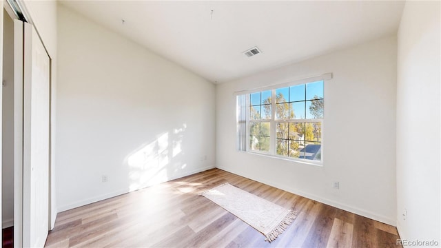 unfurnished bedroom featuring vaulted ceiling and light wood-type flooring