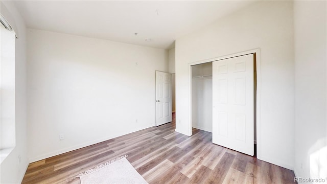 unfurnished bedroom with a closet and light wood-type flooring