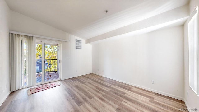 unfurnished room featuring light hardwood / wood-style flooring and lofted ceiling