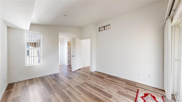 unfurnished bedroom with a textured ceiling and light wood-type flooring