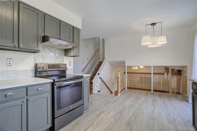 kitchen with tasteful backsplash, decorative light fixtures, stainless steel range with electric cooktop, and light hardwood / wood-style floors