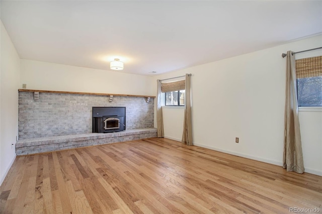 unfurnished living room with wood-type flooring and a wood stove