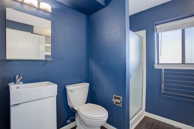 bathroom with sink, toilet, an enclosed shower, and hardwood / wood-style floors