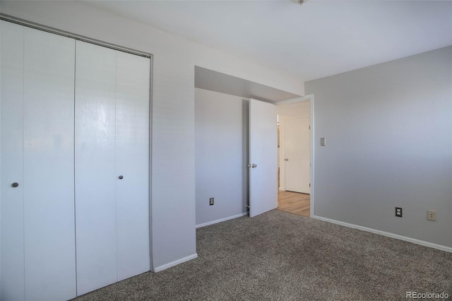 unfurnished bedroom featuring light colored carpet and a closet