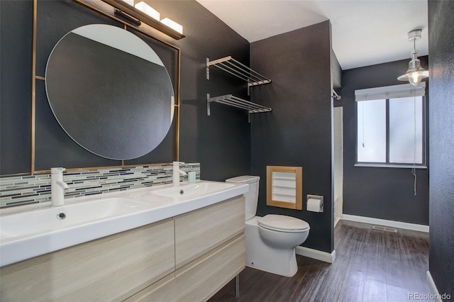 bathroom featuring tasteful backsplash, vanity, hardwood / wood-style floors, and toilet