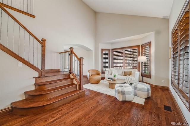 17522 E Dewberry Dr, Parker, CO 80134 - sitting room with wood finished floors, stairs, arched walkways, high vaulted ceiling, and baseboards