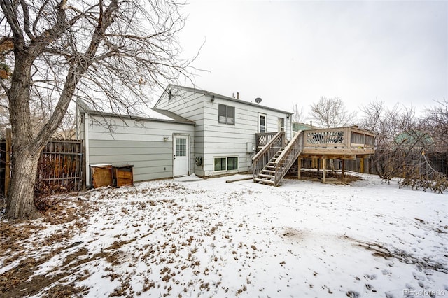 snow covered rear of property featuring a wooden deck