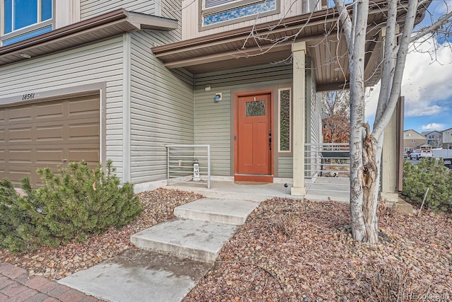 entrance to property with covered porch and a garage