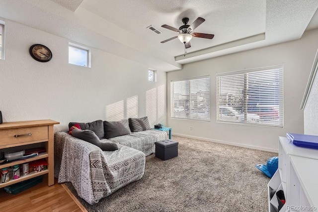 living room featuring carpet flooring, a textured ceiling, and a wealth of natural light