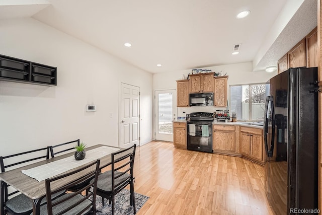 kitchen featuring sink, light hardwood / wood-style floors, and black appliances