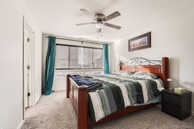 carpeted bedroom featuring ceiling fan and a textured ceiling